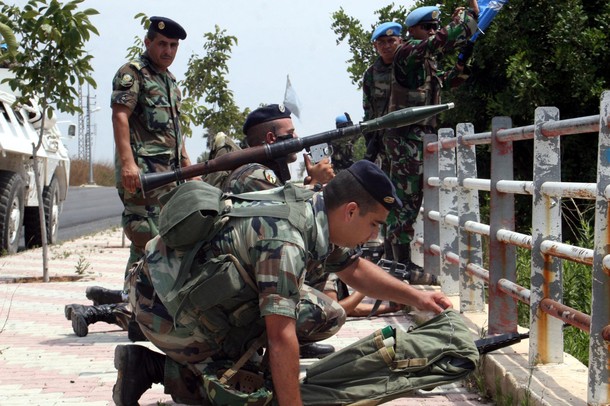 A Lebanese army soldiers (L) and UNIFIL (United Nations Interim Force in Lebanon) soldiers look across the border with Israel after brief clashes which erupted along the tense border, near the village of Adaisseh, which lies across the border from the kibbutz Misgav Am, on August 3, 2010.