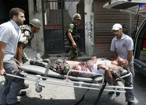 EDITORS NOTE GRAPHIC CONTENT-Civil defense workers carry an injured Lebanese soldier in the southern border village of Adaisseh, Lebanon, Tuesday, Aug. 3, 2010. Lebanon and Israeli troops exchanged fire on the border Tuesday in the most serious clashes since a fierce war four years ago